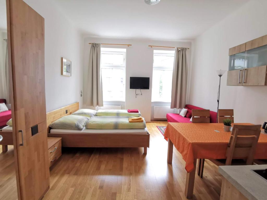 a bedroom with a bed and a living room at Apartments Hellwagstraße in Vienna