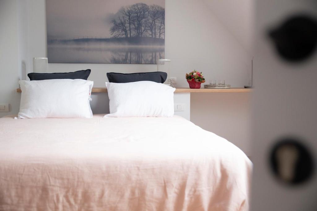 a white bed with white sheets and pillows at A Coque'Line in Frasnes-lez-Anvaing