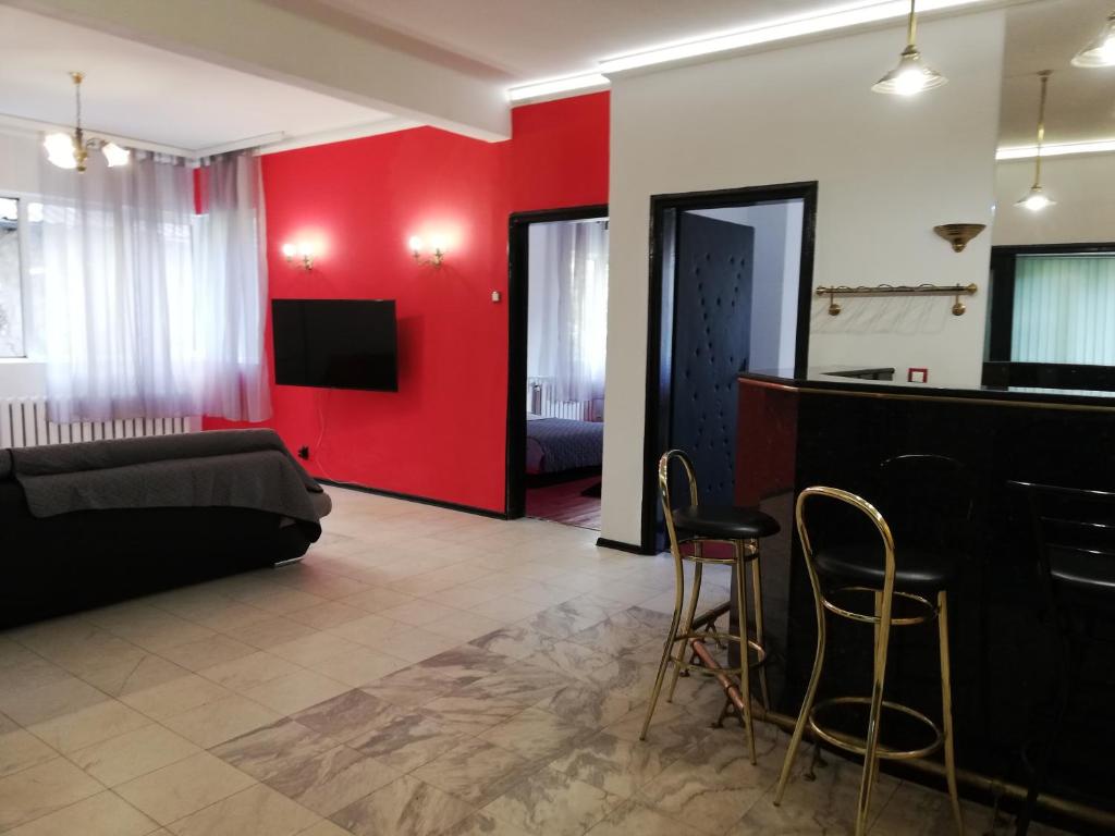 a living room with a couch and a red wall at TOP CENTER COZY AND SPACIOUS APARTMENT in Sofia