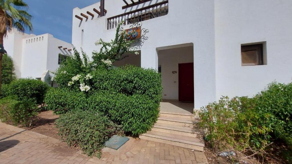 a white building with a staircase and some bushes at Delta Sharm Apartment 156 flat 102 in Sharm El Sheikh