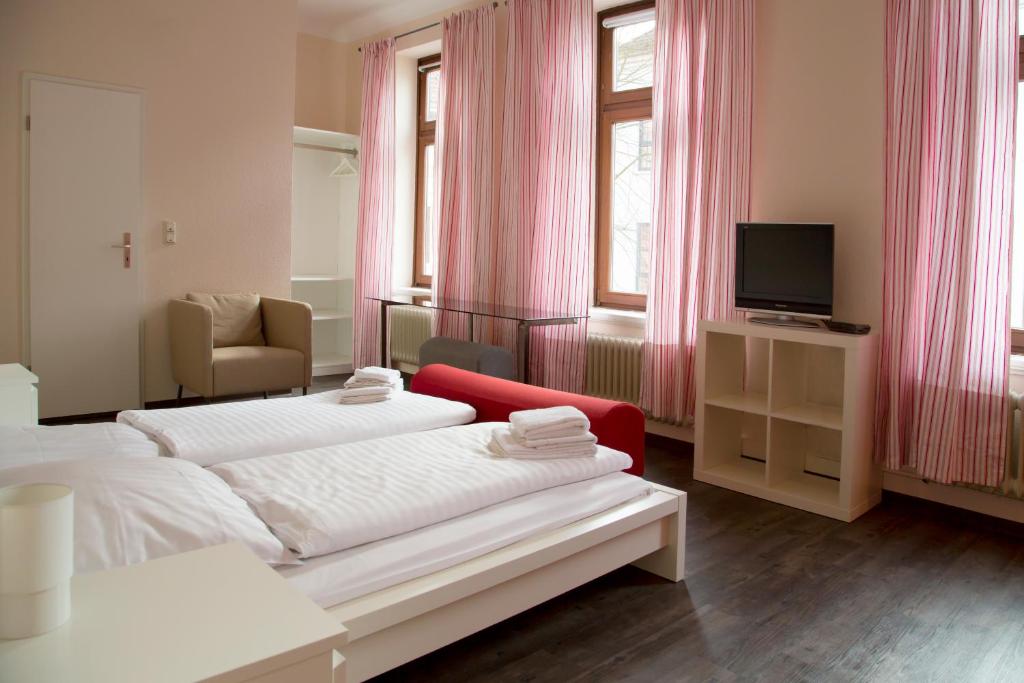 ein Hotelzimmer mit 2 Betten und einem TV in der Unterkunft Boardinghouse Vegesack in Bremen-Vegesack