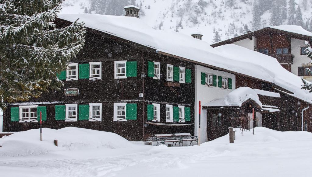 レッヒにあるSandbur Das Walserhausの雪山の建物