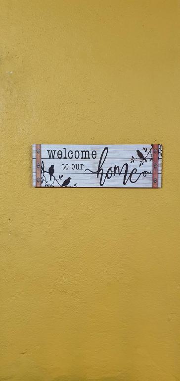 a welcome to our home sign on a yellow wall at Serene Homes in Banting