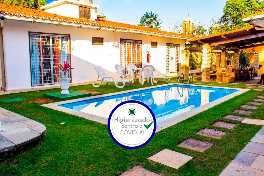 a house with a swimming pool in the yard at Pousada Italia in Natal