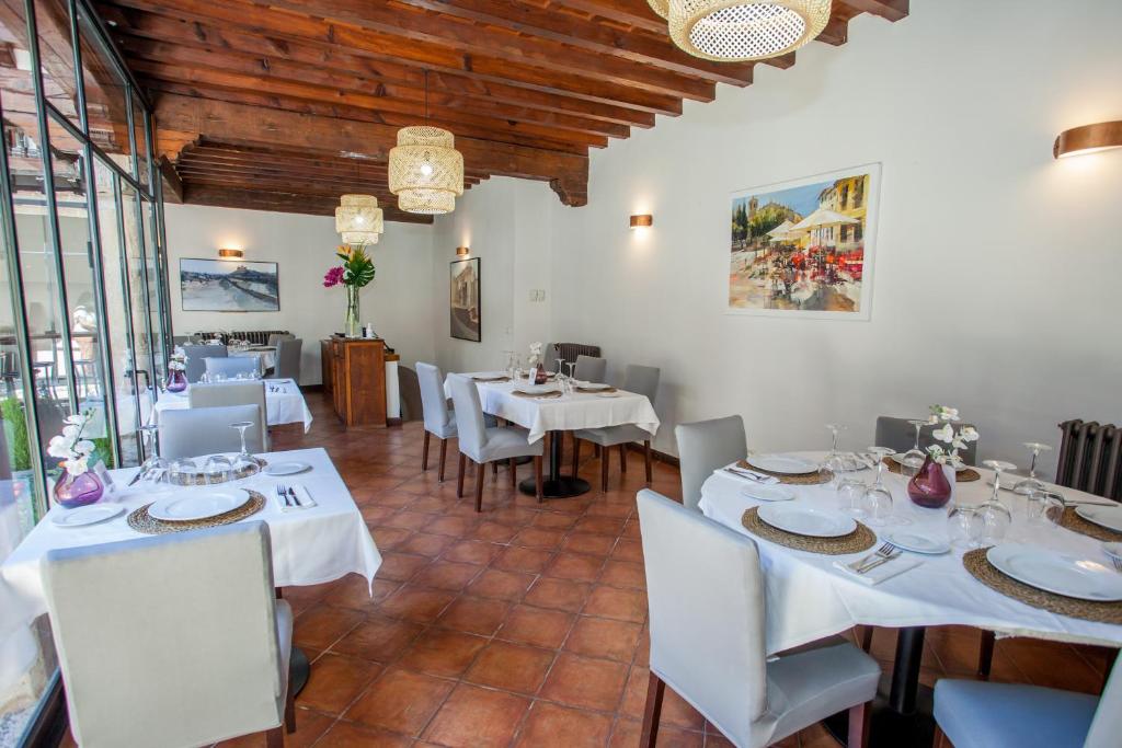 a dining room with white tables and chairs at Hotel Casa Palacio Uclés in Uclés
