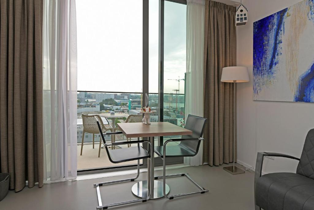 a room with a table and chairs and a large window at Black Jack Suites Amsterdam in Amsterdam