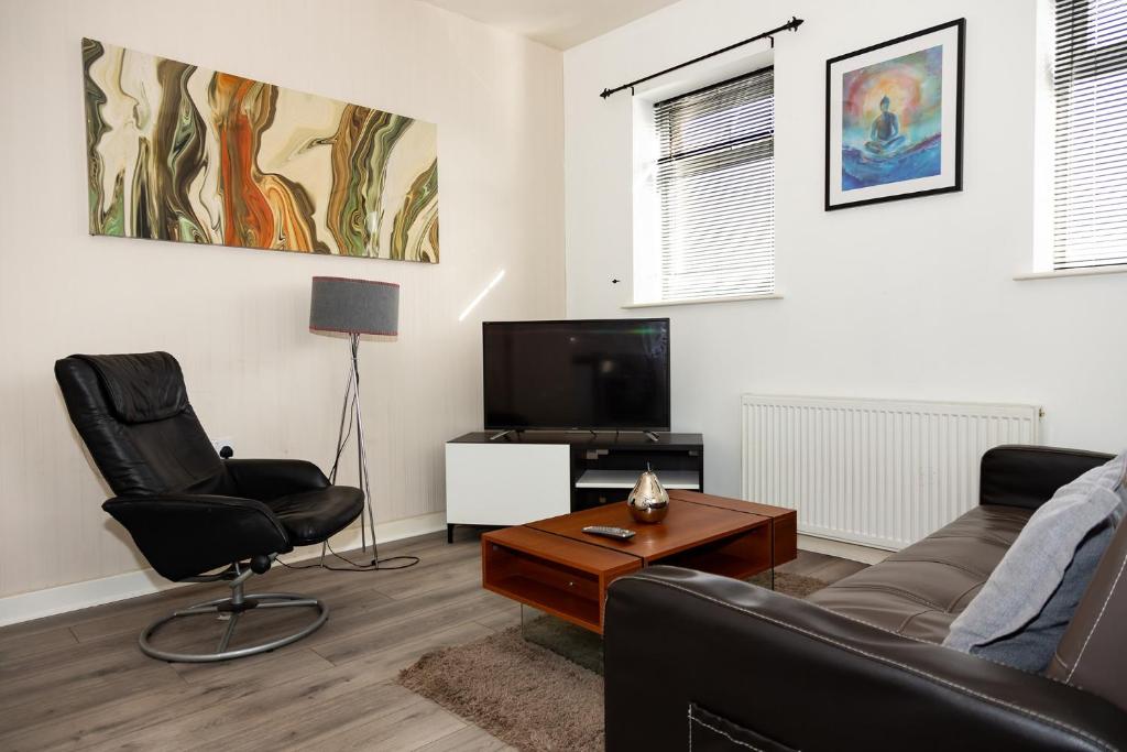 a living room with a couch and a tv at Alexander Apartments Roker in Sunderland