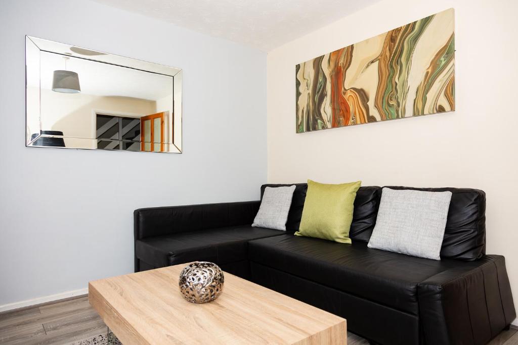 a living room with a black couch and a table at Backworth - Alexander Apartments in Backworth