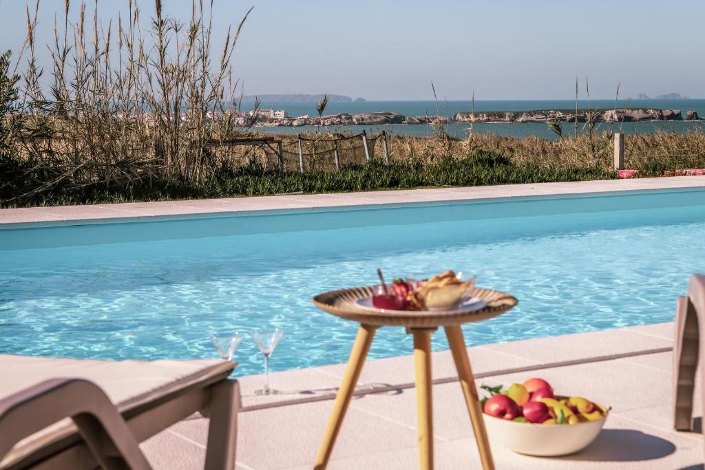 eine Schale Obst auf einem Tisch neben einem Pool in der Unterkunft Marlin House IV in Ferrel