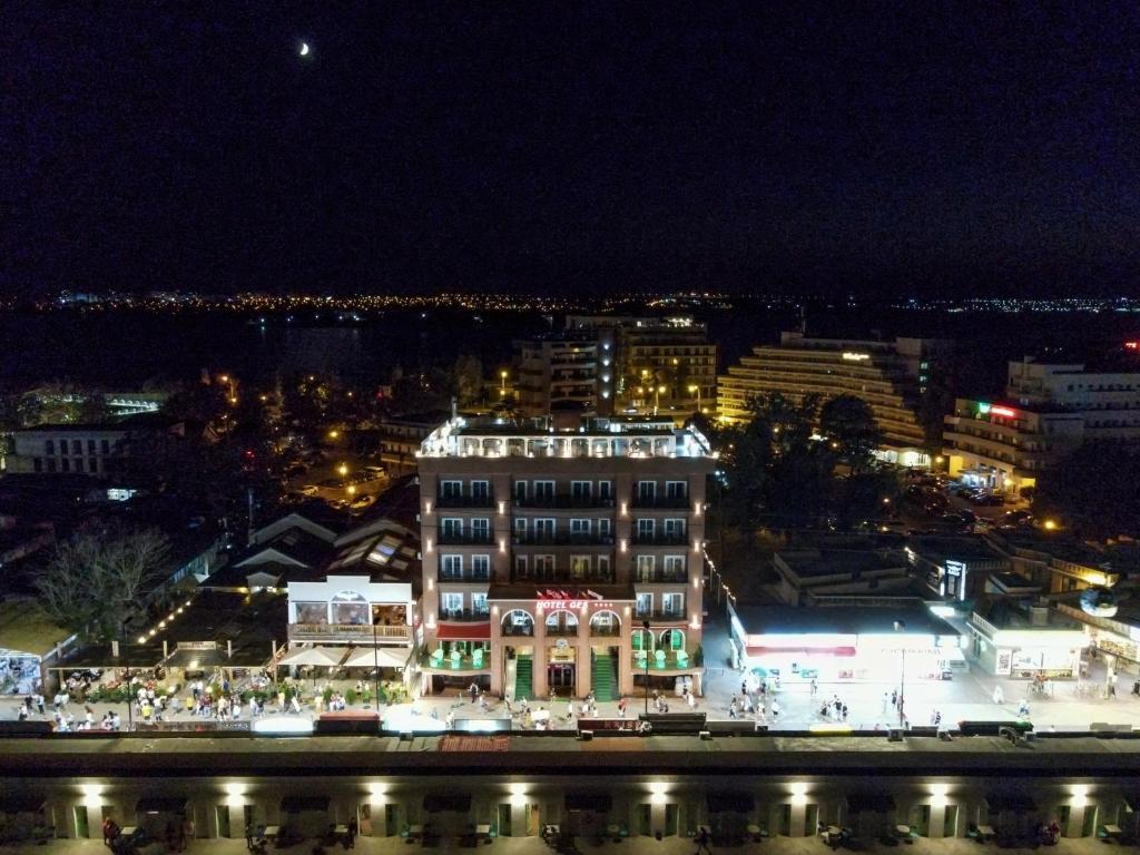 una ciudad iluminada por la noche con un edificio en Hotel Ges en Mamaia