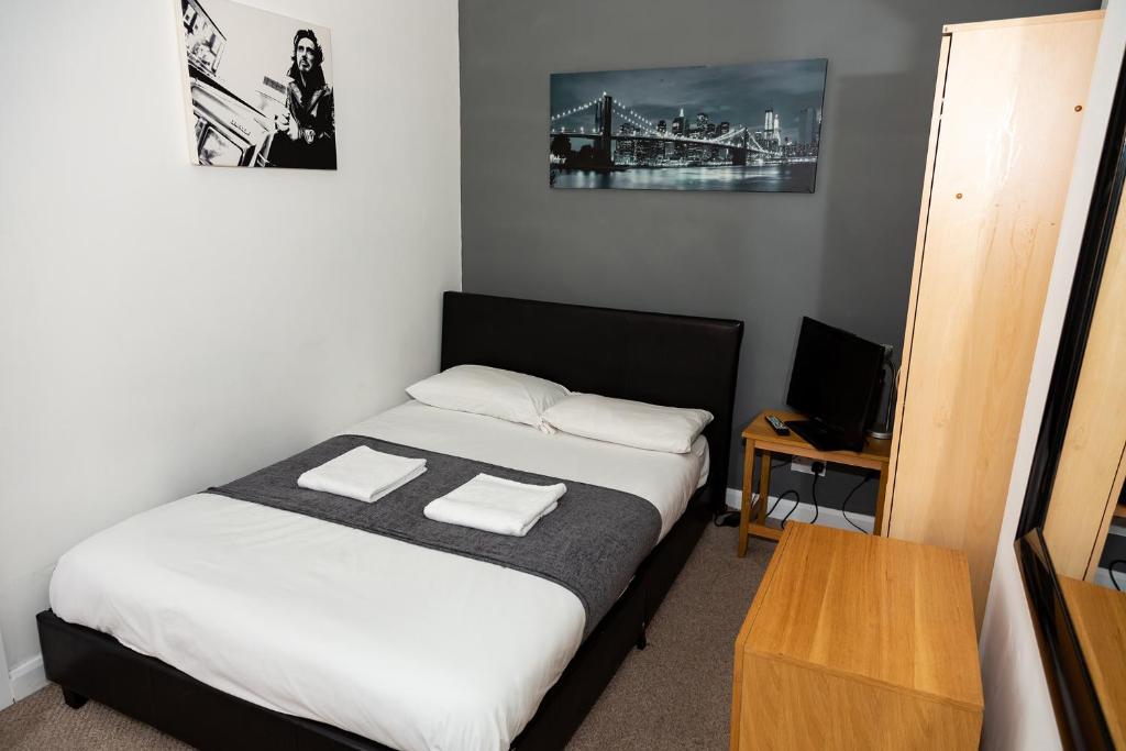 een slaapkamer met een bed met twee handdoeken erop bij South Shields Central in South Shields