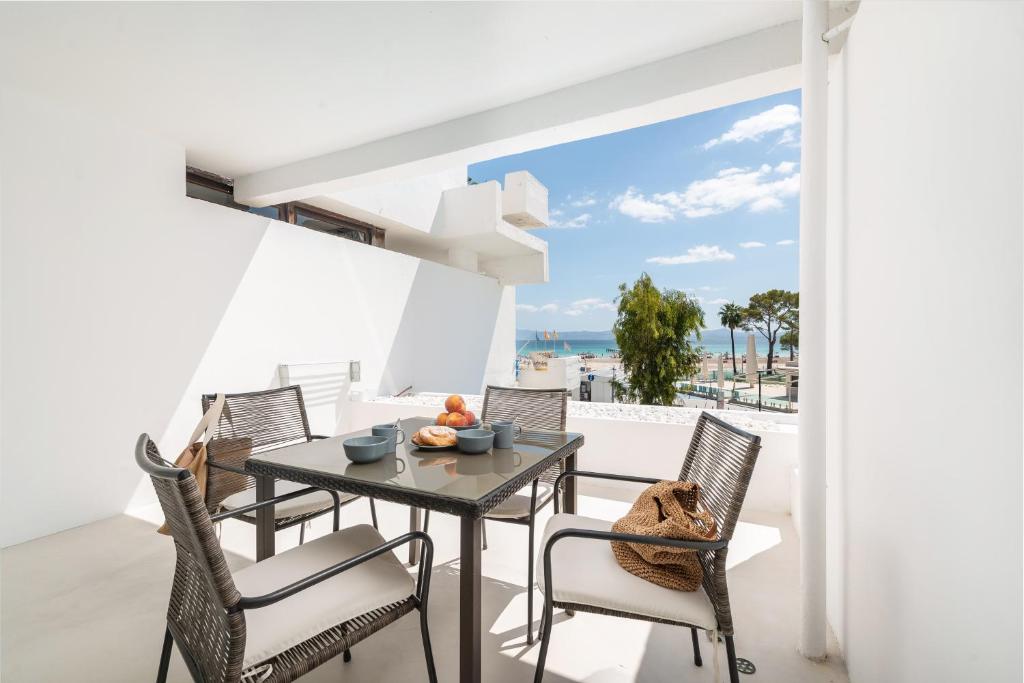 a dining room with a table and chairs and a view of the ocean at Sa Nacra in Alcudia