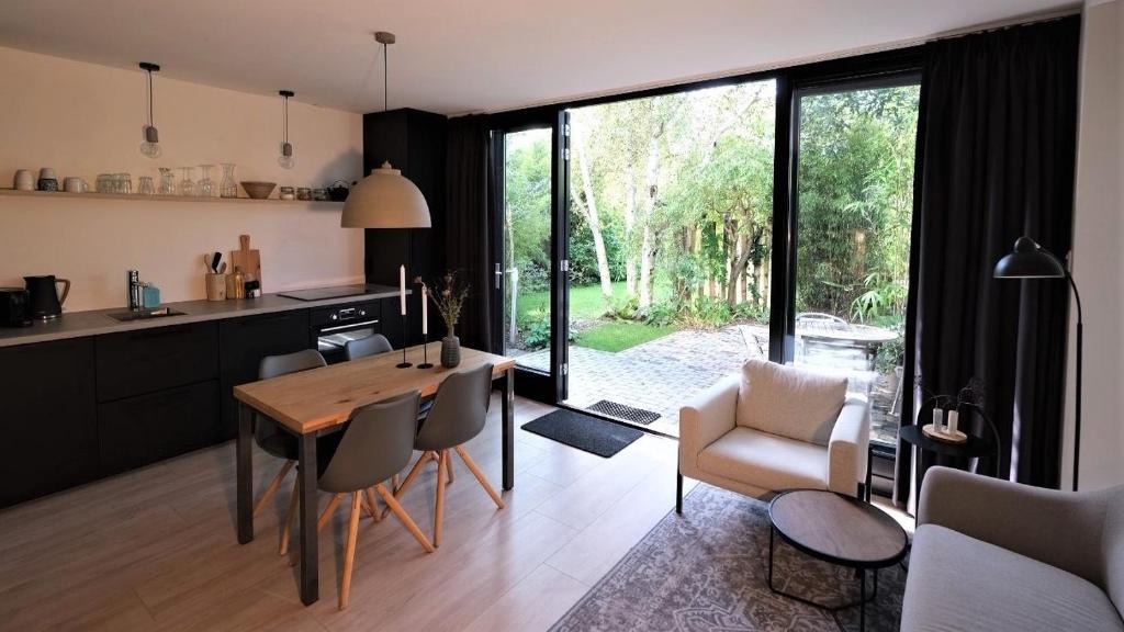 a kitchen and living room with a table and chairs at B&B behind the tree in Hoofddorp