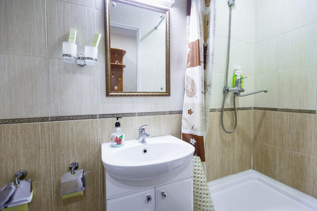 a bathroom with a sink and a shower with a mirror at Inn Zolotaya Melnitsa in Belogorsk