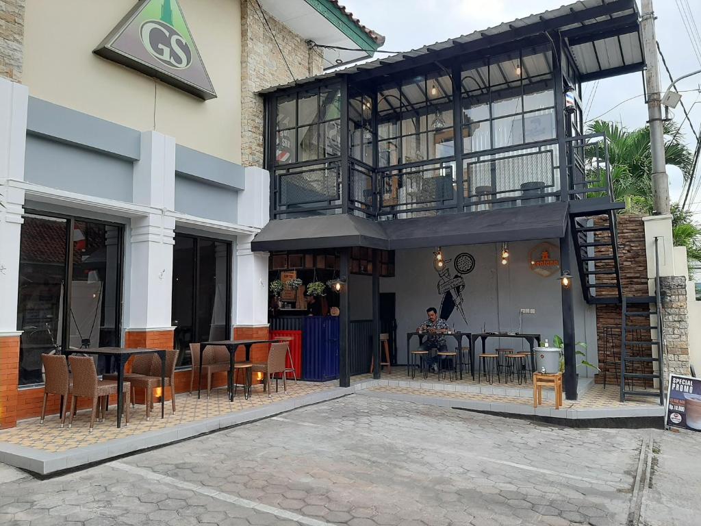 a building with a table and chairs in front of it at Griya Sentana Hotel in Yogyakarta