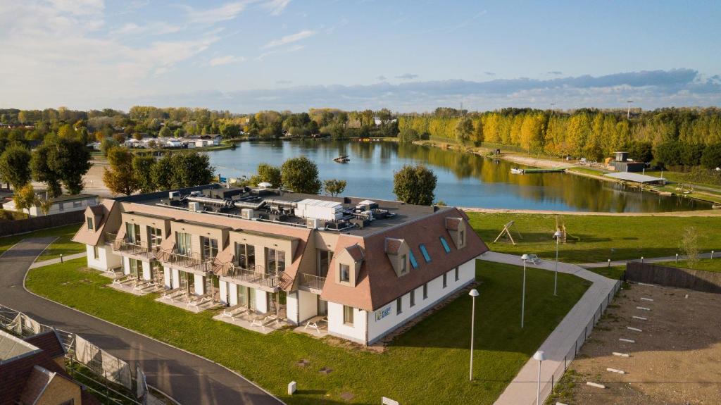 een luchtzicht op een groot huis naast een rivier bij Holiday Suites Jabbeke in Jabbeke