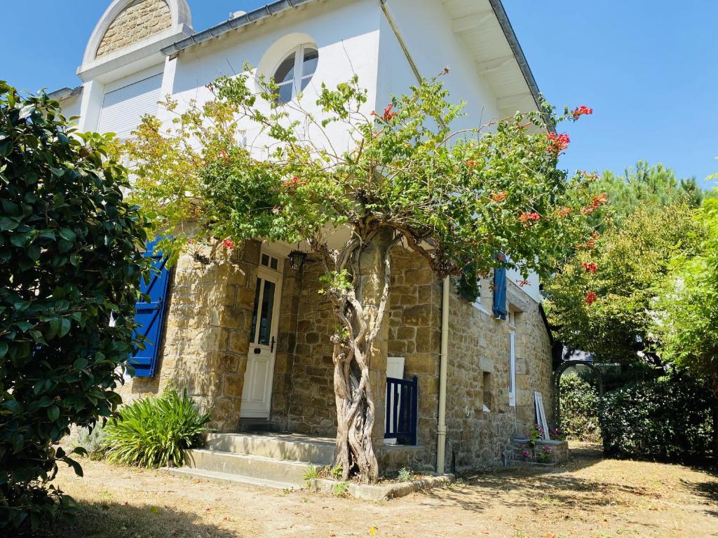 Una casa blanca con un árbol delante. en Druides 2 en Carnac