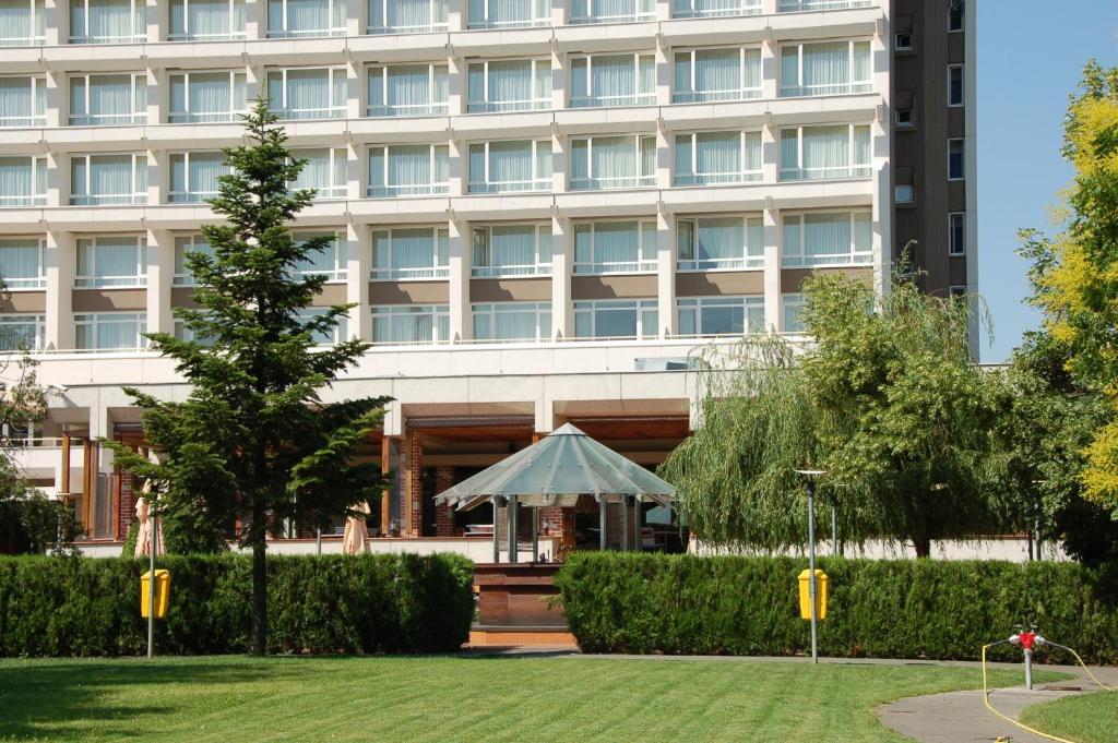 un bâtiment avec un kiosque devant lui dans l'établissement Ramada by Wyndham Bucharest Parc Hotel, à Bucarest