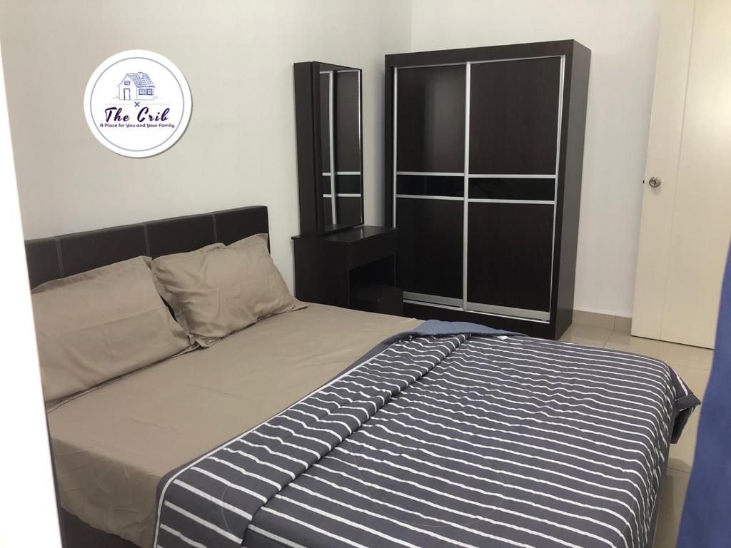 Schlafzimmer mit einem Bett mit blauen und weißen Streifen in der Unterkunft The Crib @ Desaru in Desaru
