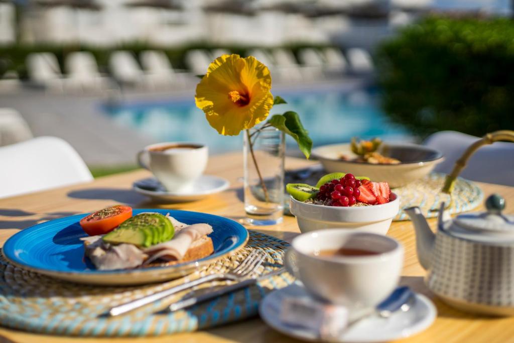 a table with a plate of food and cups of coffee at Camelina Suites in San Antonio Bay