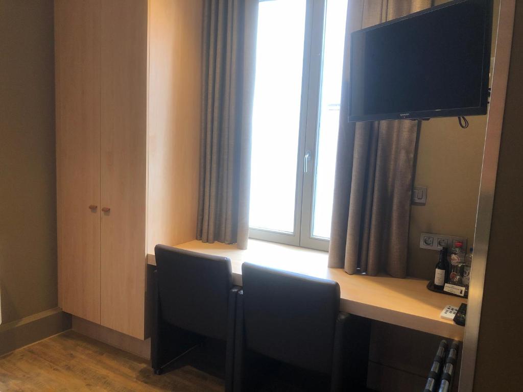 TV a/nebo společenská místnost v ubytování Hotel Duivels Paterke Harelbeeksestraat 29, 8500 Kortrijk