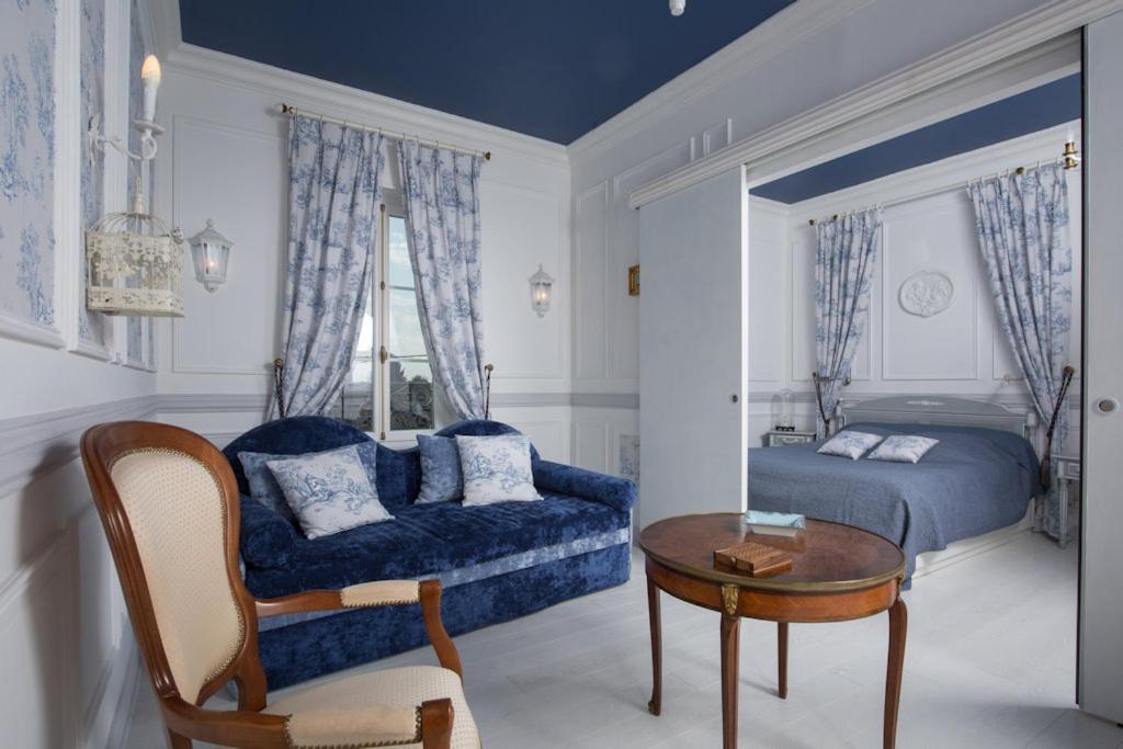 1 dormitorio con cama, mesa y sofá en Villa Dufresne en Beynost