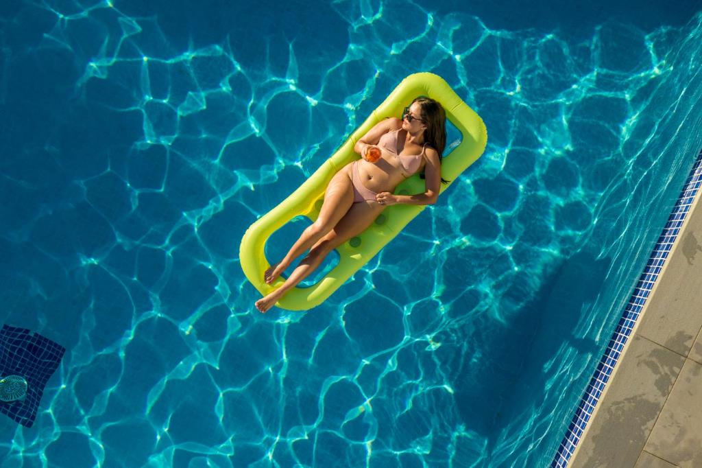 a woman floating on a raft in a swimming pool at Camelina Suites in San Antonio Bay