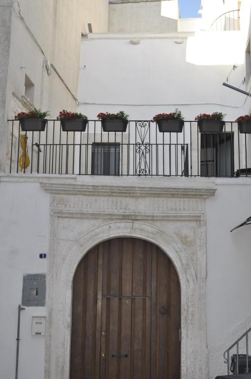 a building with a wooden door and flowers on a balcony at acasa in Martina Franca