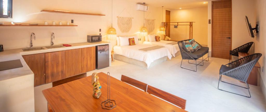 um quarto com uma cama e uma cozinha com um sofá em Nuee Hotel & Beach Club em Tulum