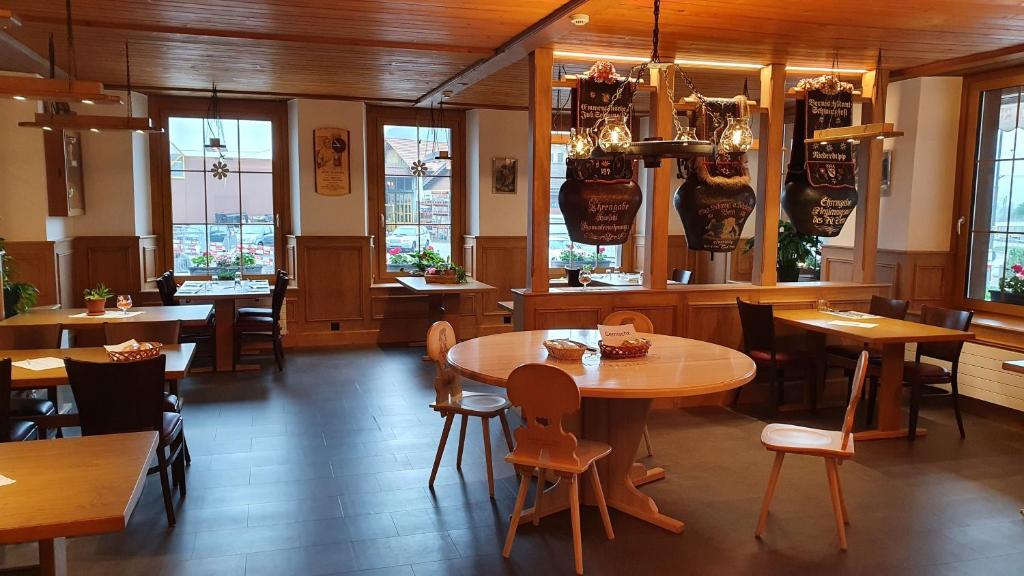维尔德斯韦尔Gasthof Hirschen in Wilderswil的餐厅设有木桌、椅子和窗户。