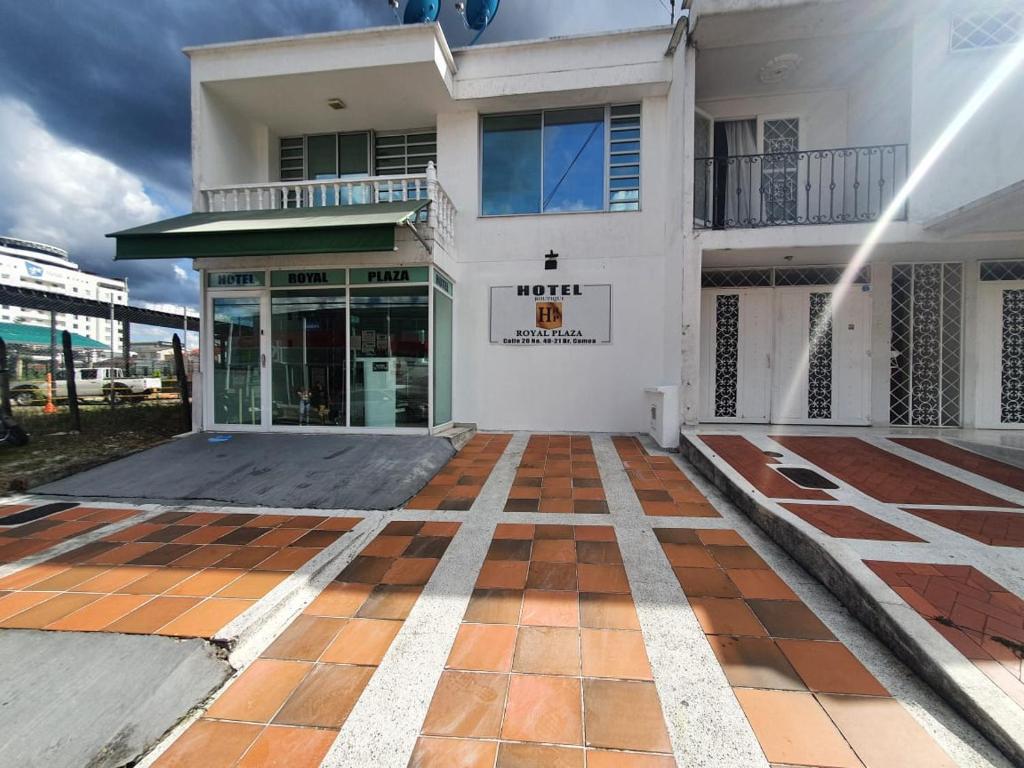 a white building with a tiled floor in front of it at Hotel Royal Plaza in Villavicencio