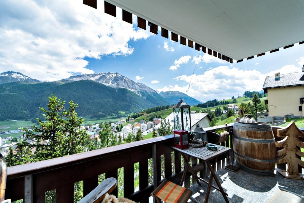 a balcony with a view of a town and mountains at Chesa Flurigna - Zuoz in Zuoz