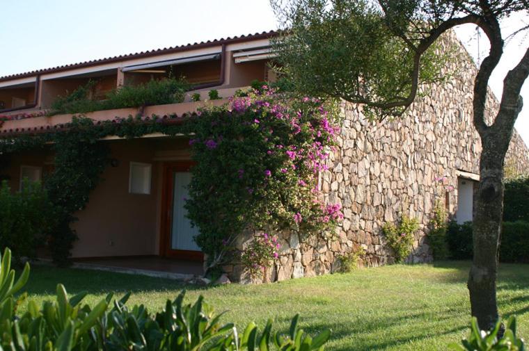 a building with flowers on the side of it at Residence Porto Coda Cavallo in San Teodoro