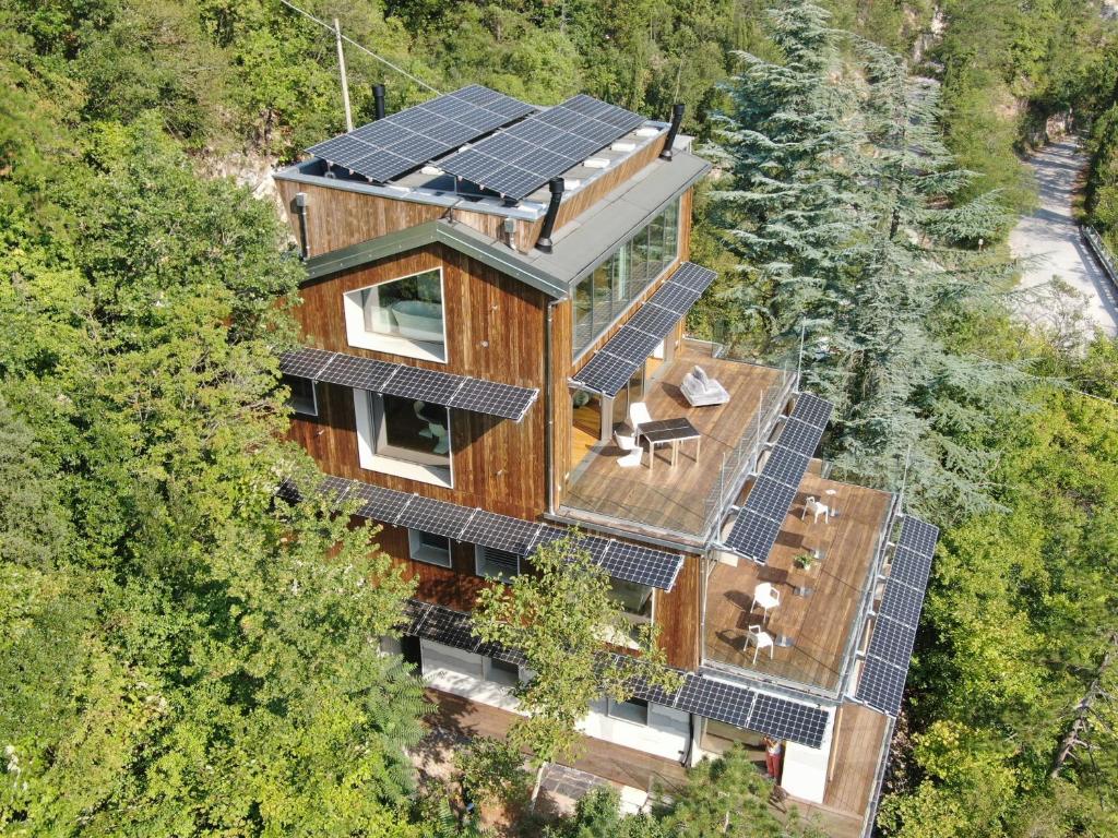 La Forestale Luxury Ecolodge B&B Primo Piano في أكوالاغنا: اطلالة جوية على منزل عليه لوحات شمسية