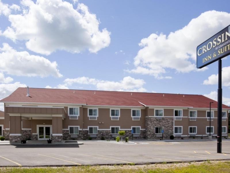 un edificio con un letrero de la calle delante de él en Grandstay Hotel and Suites Parkers Prairie en Parkers Prairie