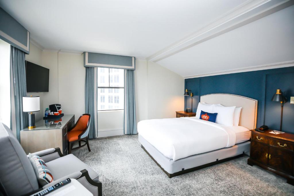 Pokój hotelowy z łóżkiem i krzesłem w obiekcie Dunhill Hotel w mieście Charlotte