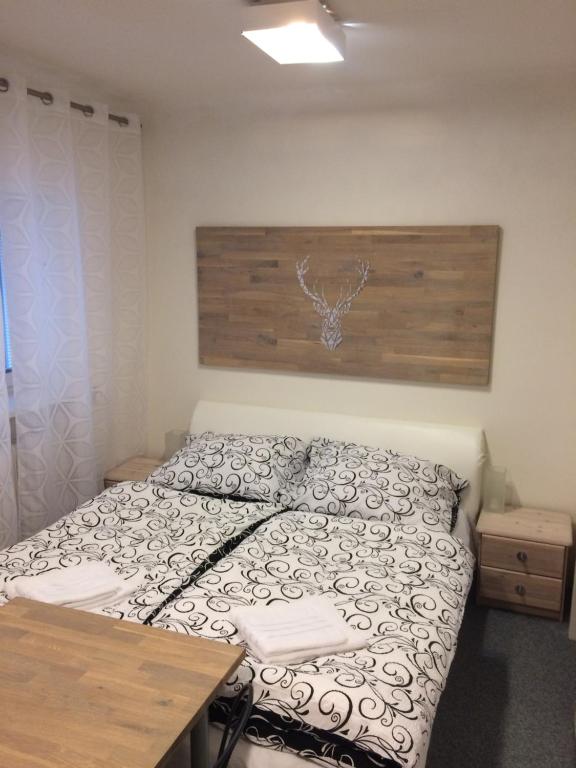ブルノにあるApartmán Brno Jeleniceのベッドルーム1室(木製ヘッドボード付きのベッド1台付)