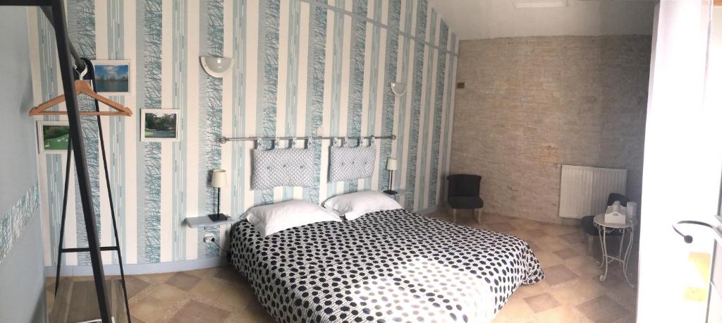- une chambre avec un lit noir et blanc et un mur dans l'établissement Le Logis de la Venise Verte, à Saint-Hilaire-la-Palud