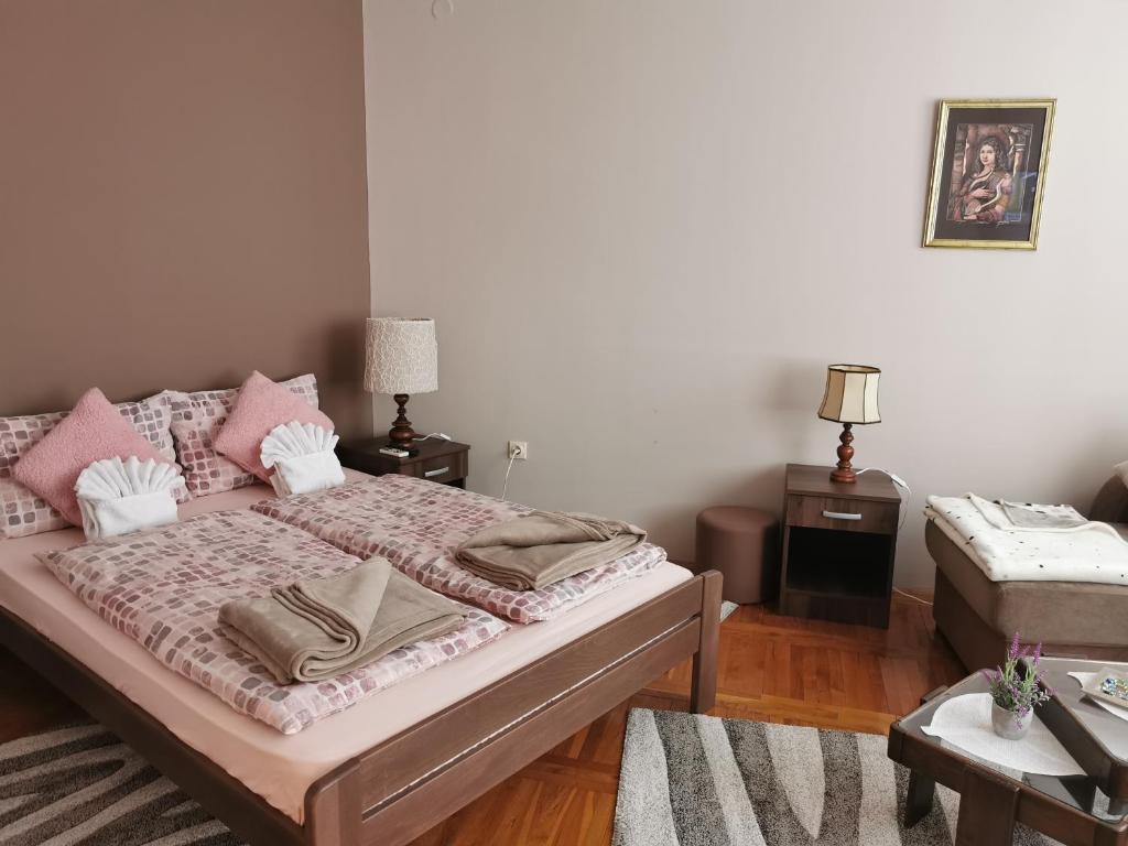 a bedroom with a bed with pink pillows at Kata's Place in Subotica
