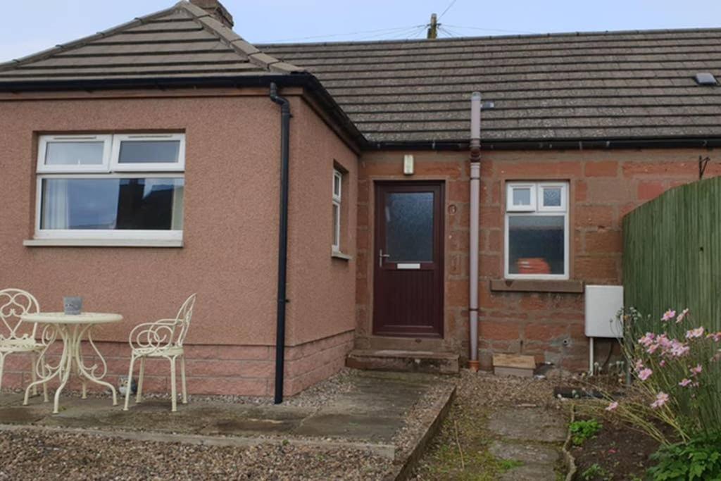 a house with a table and chairs in front of it at Little Red Kirriemuir in Kirriemuir