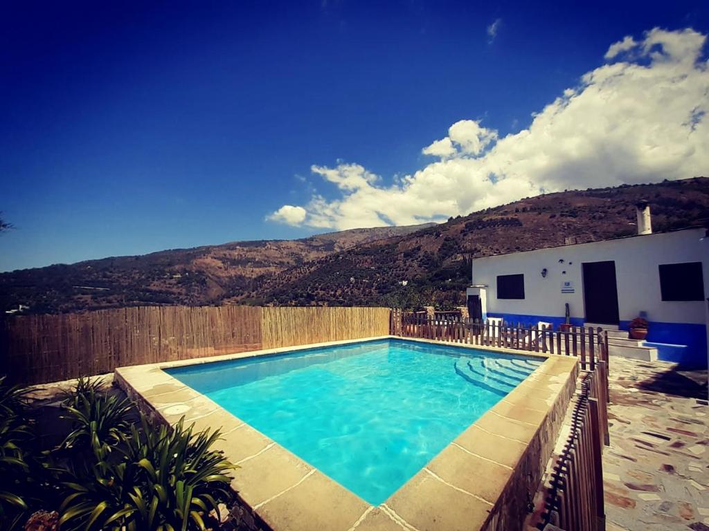 une piscine avec une montagne en arrière-plan dans l'établissement La Encina, à Lanjarón