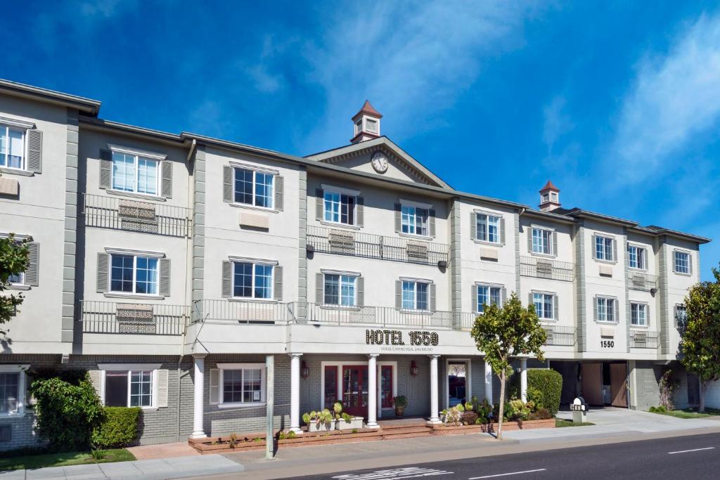 a large white building on the corner of a street at Hotel 1550 - SFO Airport West in San Bruno