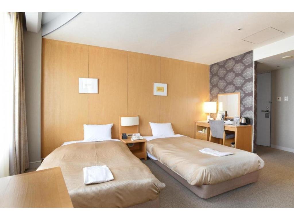 um quarto de hotel com duas camas e uma secretária em Hotel Grand Vert Gizan - Vacation STAY 95355 em Gifu