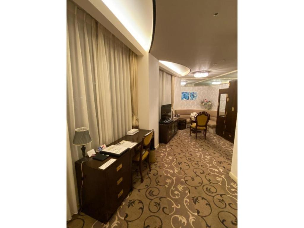 Hotel Grand Vert Gizan - Vacation STAY 95368 في غيفو: غرفة في الفندق مع مكتب وغرفة