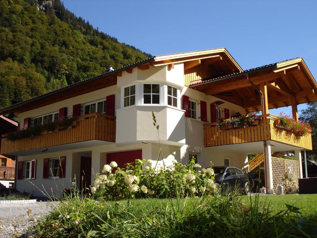 ein Haus mit einem Balkon mit Blumen darauf in der Unterkunft Haus Telisia in Klösterle am Arlberg