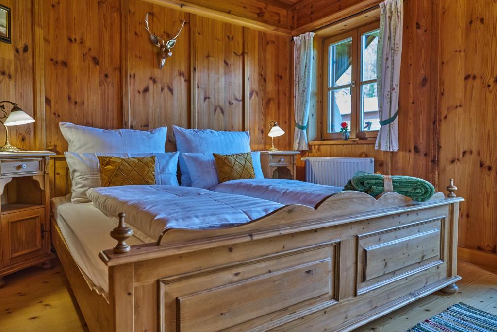 a large bed in a room with wooden walls at Ewinger Lodge in Bad Goisern
