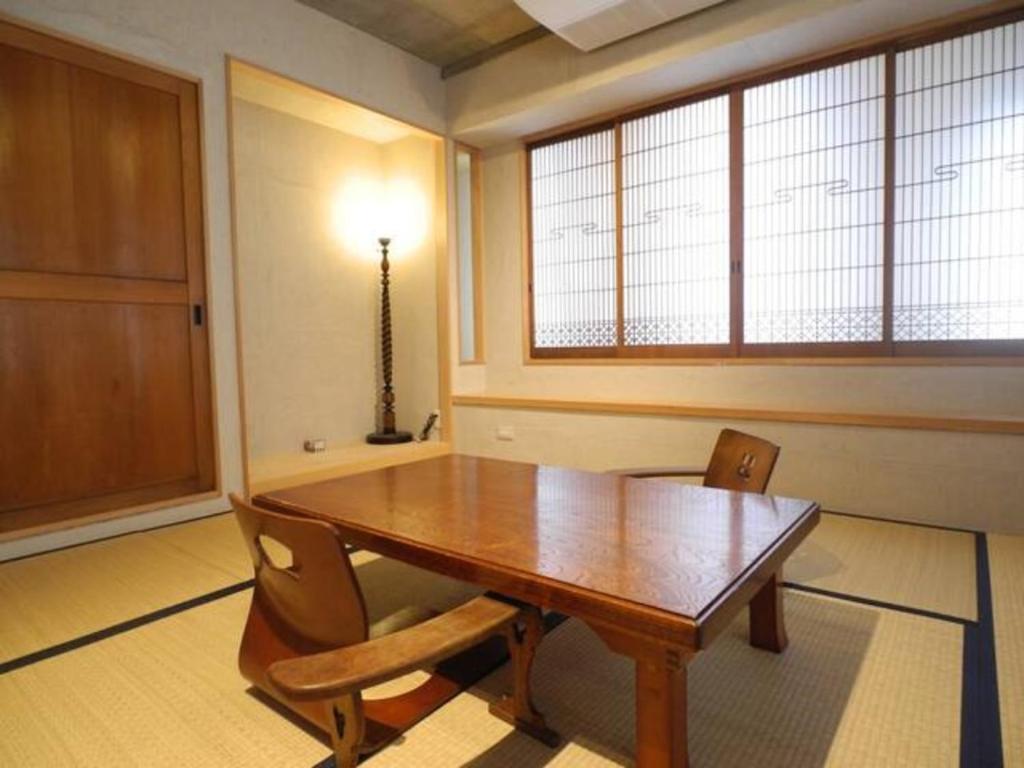 uma sala de jantar com uma mesa de madeira e cadeiras em New Art Building - Vacation STAY 95765 em Tóquio