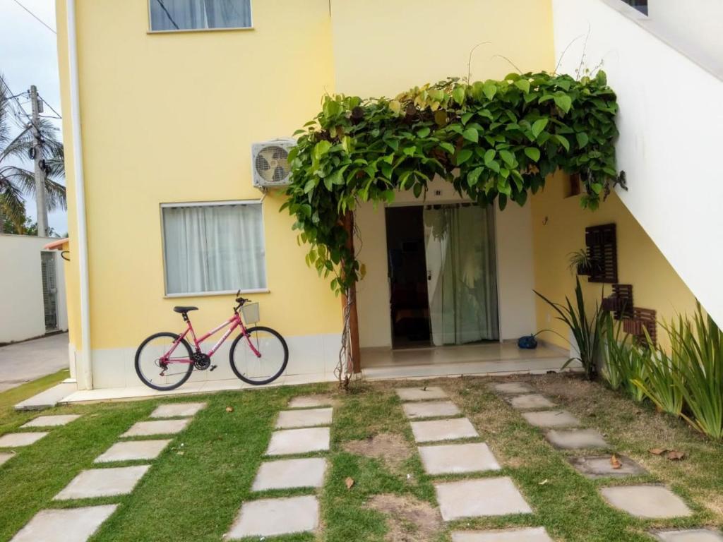 uma bicicleta estacionada em frente a uma casa em Residencial Praia dos Corais em Coroa Vermelha