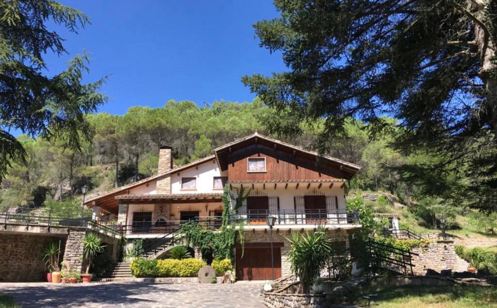 ein Haus auf einem Hügel mit Bäumen im Hintergrund in der Unterkunft Els Avets de la Muga in Sant Llorenç de la Muga