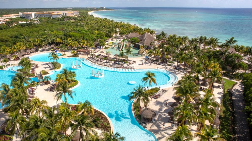 a beach filled with palm trees and palm trees at Grand Palladium Colonial Resort & Spa - All Inclusive in Akumal